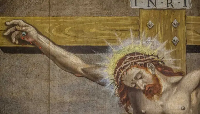 Zbliżenie na cierpiącego Jezusa na krzyżu. Widoczna korona cierniowa, rana na dłoni i napis INRI.