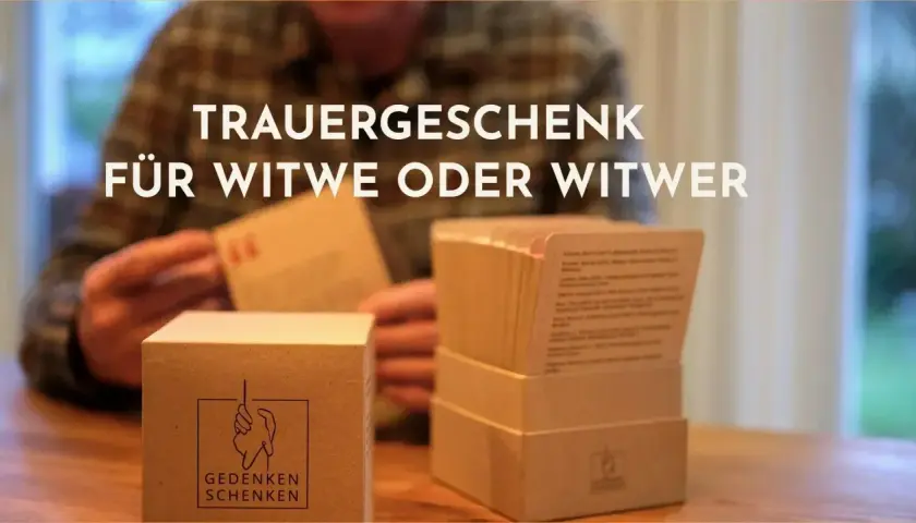 Ein Mann, der sich einsam und verwitwet fühlt, hält eine Karte aus einem Trauergeschenk.