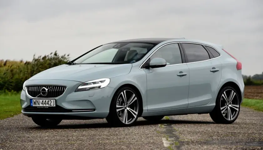 Jasnoszary Volvo V40 na drodze, z widocznymi felgami i oponami. Idealny rozmiar opon dla tego modelu.