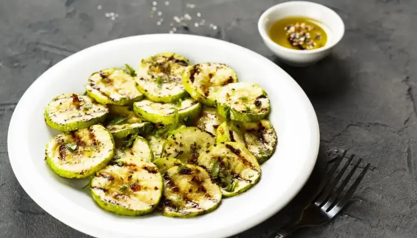 Zucchine alla scapece non fritte, grigliate e condite con erbe aromatiche e olio. Un piatto leggero e saporito.