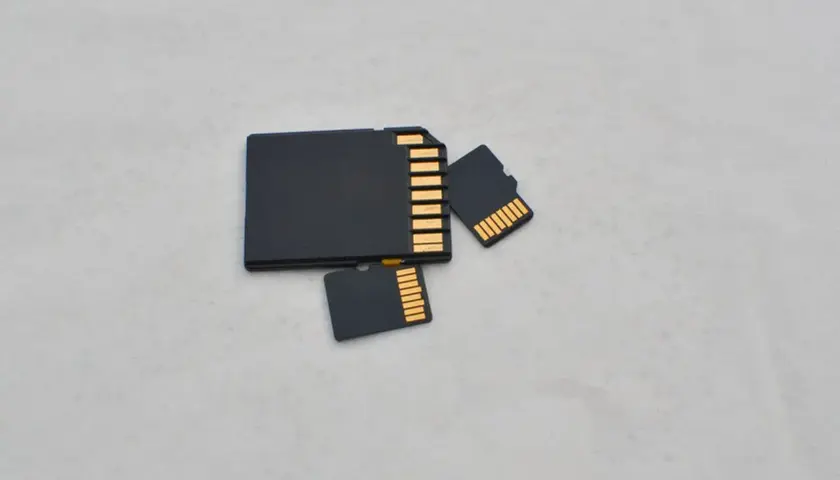 Porównanie rozmiarów: duża karta SD i dwie mniejsze karty microSD (TF). Różnica w wielkości jest oczywista.