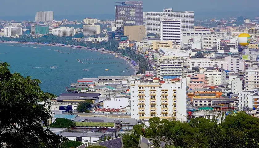 Widok na nadmorskie miasto z wieloma budynkami, plażą i morzem. Zastanawiasz się, ile kosztują mieszkania w Tajlandii?