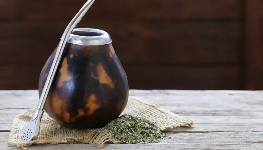 Naczynie do yerba mate, matero palo santo, gotowe do pierwszego użycia. Obok garść suszu i metalowa bombilla.