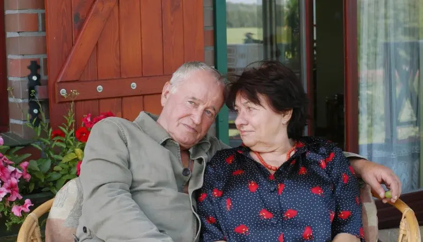 Para siedzi na werandzie. Mężczyzna ma siwe włosy, kobieta ciemne. Nie wiadomo, ile lat ma Anna Kondratowicz.