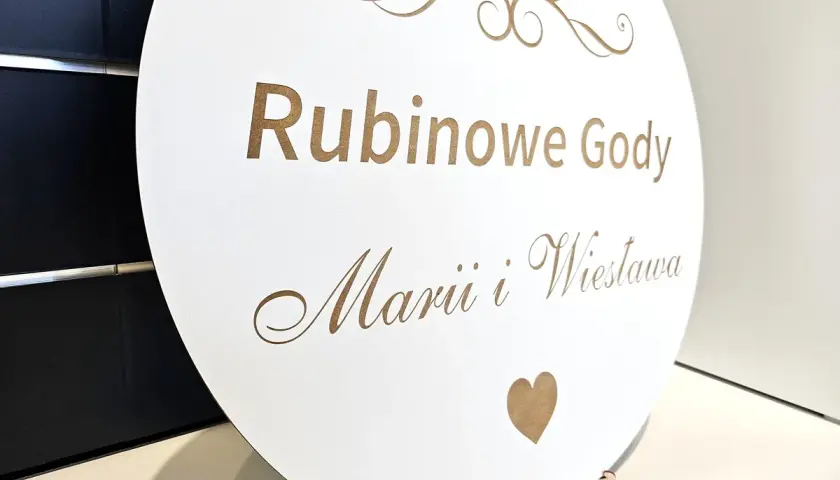 Okrągła tablica z napisem "Rubinowe Gody Marii i Wiesława" i cyfrą 40. Piękne życzenia na 40 rocznicę ślubu.