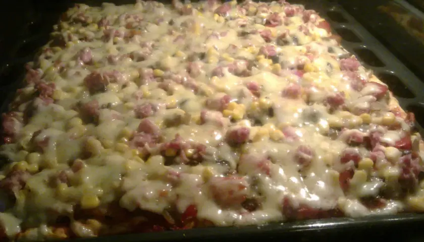 Pyszna pizza z kukurydzą i wędliną, właśnie wyjęta z piekarnika. Ania gotuje i tworzy cuda!