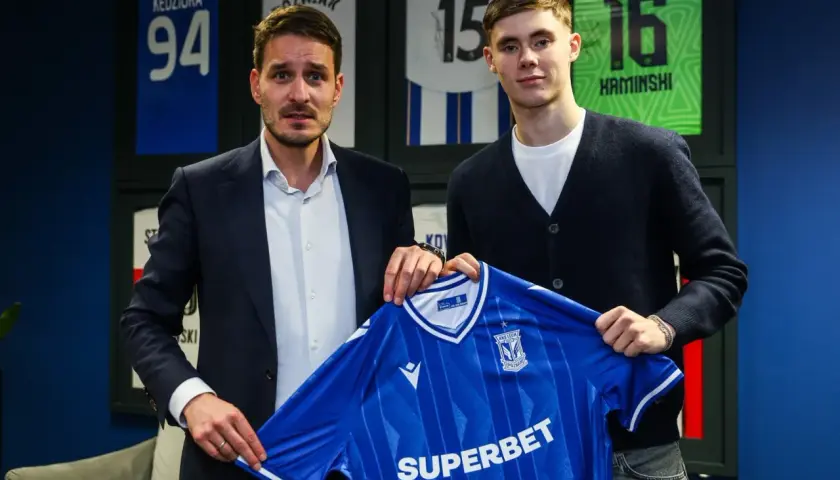 Dwaj mężczyźni prezentują niebieską koszulkę Lecha Poznań. To kolejny z transferów klubu.