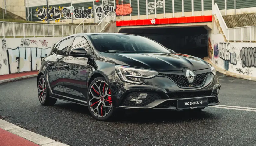 Czarny Renault Megane RS na tle graffiti. Idealny wybór dla tych, którzy szukają sportowych emocji i atrakcyjnego **leasingu Renault Megane**.