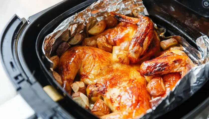 Pollo dorato e patate croccanti in friggitrice ad aria, un pasto delizioso pronto in poco tempo.