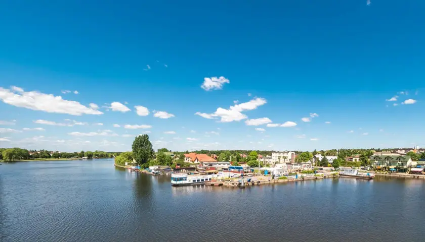 Port w Augustowie z widokiem na jezioro i zabudowania. Wspaniałe augustowskie atrakcje czekają na odkrycie!