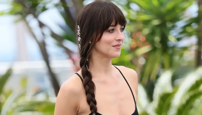 Mujer con flequillo y una trenza lateral adornada con accesorios plateados, luciendo unas trenzas de moda.