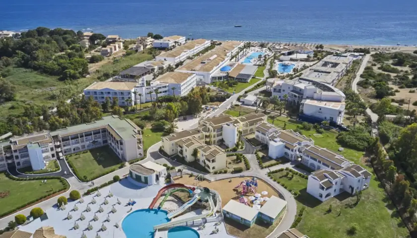 Widok z lotu ptaka na kompleks hotelowy z basenami, zjeżdżalniami i placem zabaw, blisko plaży. Wiele budynków, zieleni i morza. Idealne miejsce na wakacje, zgodnie z labranda sandy beach resort opinie.