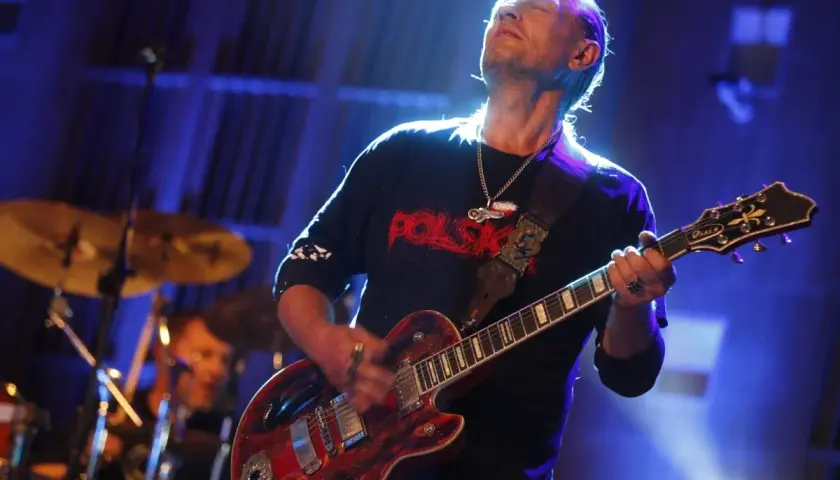 Andrzej Nowak z TSA gra na gitarze, zamykając oczy w transie.