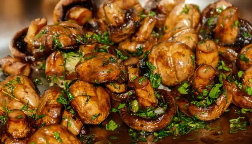Champignons sautés, brillants et garnis de persil frais. Une recette simple et savoureuse pour sublimer ce légume.