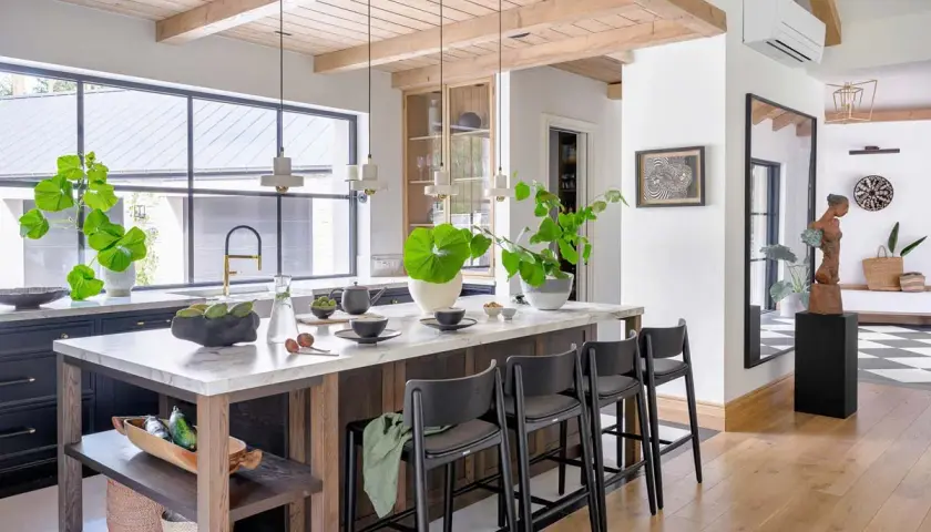 Nowoczesna kuchnia w stylu **styl modern farmhouse** z wyspą, marmurowym blatem, drewnianymi belkami i dużą ilością zieleni.