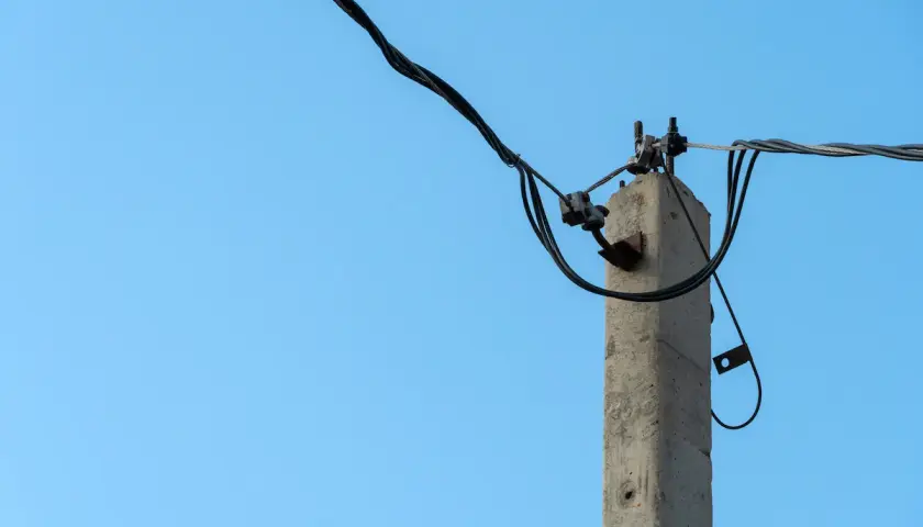 Betonowy słup energetyczny z przewodami. Dyskusja na forum o odszkodowanie za słupy energetyczne.