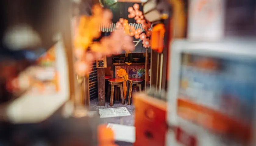 Miniaturowy japoński zaułek z dwoma stołkami, idealny do stworzenia własnego **diy book nook**.