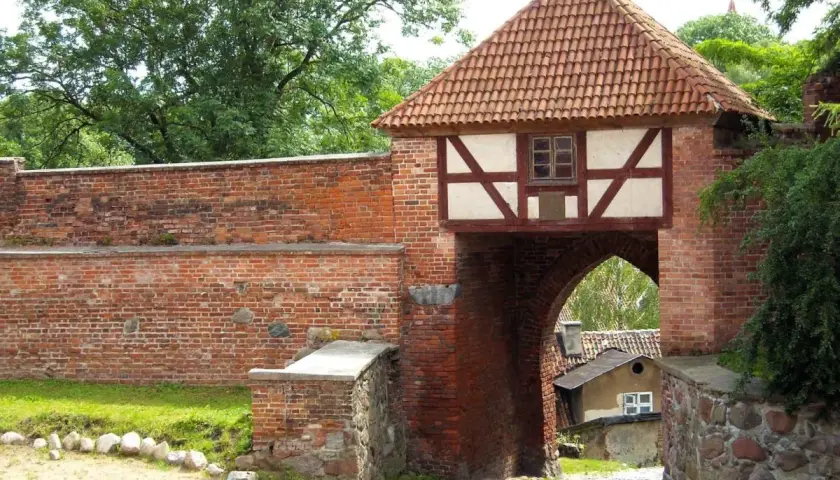 Brama miejska w Pasłęku, z charakterystycznym dachem i szachulcową nadbudową, to jedna z głównych atrakcji miasta.