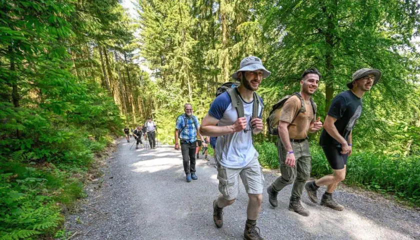 Grupo de excursionistas disfrutando de rutas de senderismo para principiantes en un bosque frondoso.