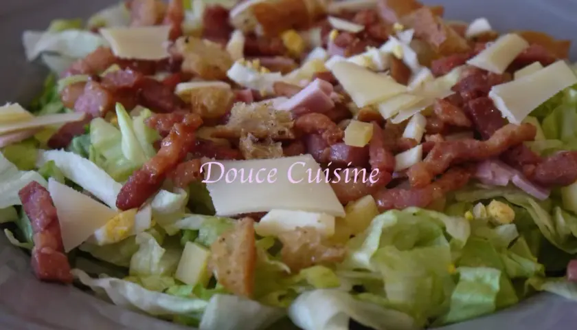 Salade savoyarde généreuse avec lardons, fromage, œuf dur et croûtons. Un délice pour les papilles.