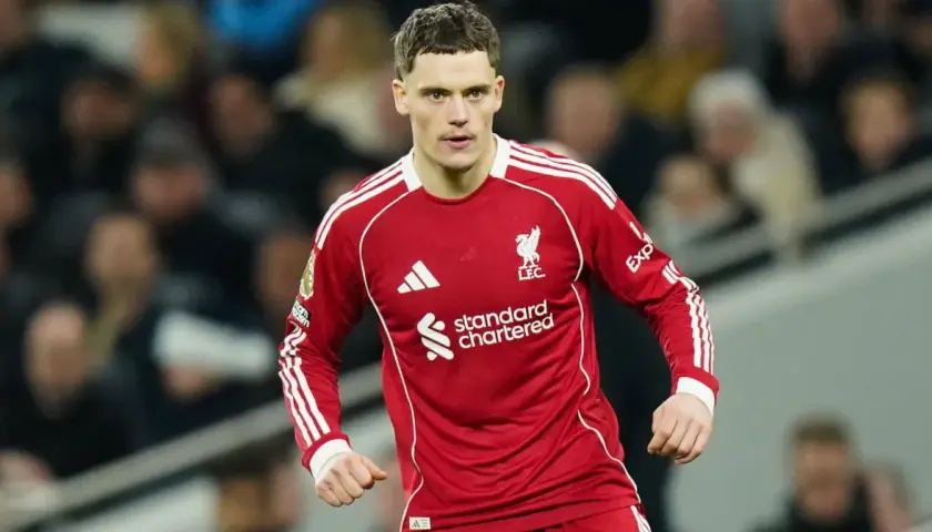 Piłkarz Liverpoolu w czerwonej koszulce, gotowy do gry. Jego determinacja może wpłynąć na rankingi Liverpoolu.