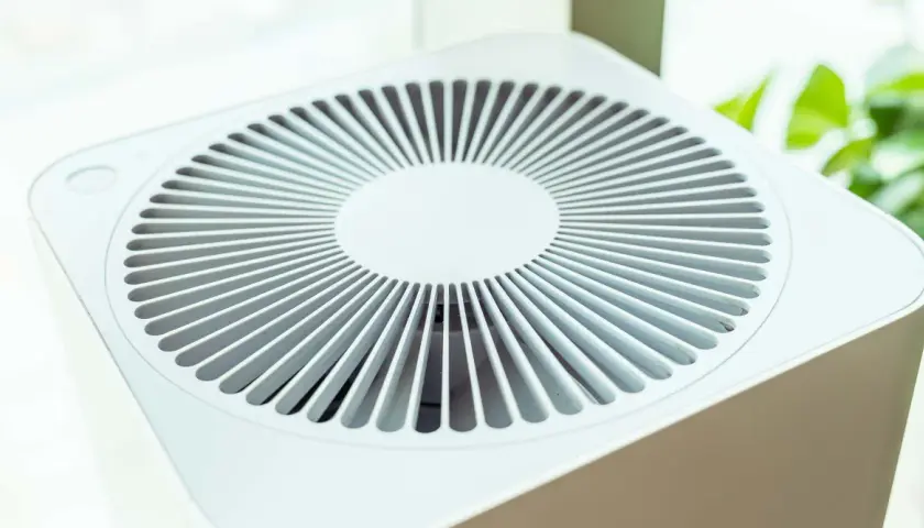 Purificador de aire blanco con rejilla circular. Considera las contraindicaciones del purificador de aire para un uso seguro y efectivo.