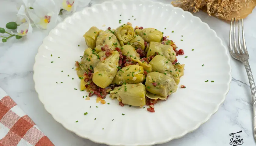 Alcachofas de bote salteadas con jamón y cebolla, un plato sencillo y delicioso. ¡Perfecto para tus recetas con alcachofas de bote!