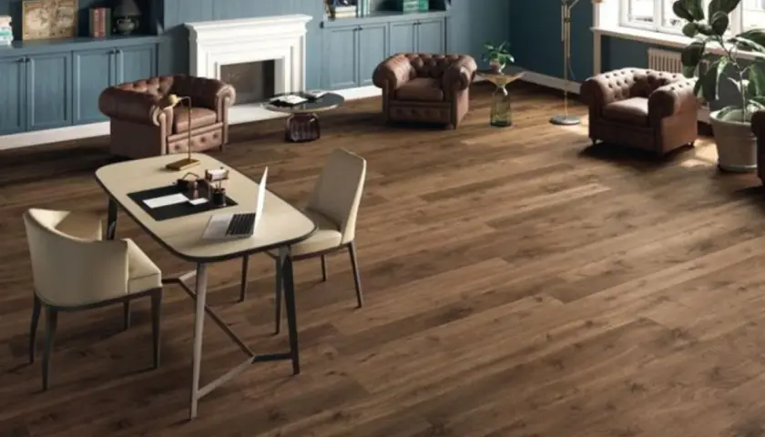 Un elegante soggiorno con camino, poltrone in pelle e un tavolo da lavoro. Il pavimento in legno scuro, perfetto per la posa pavimenti, completa l'arredamento.