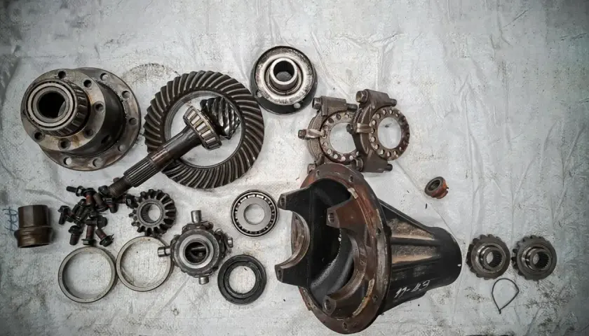 Rozłożony dyfer z zębatkami, wałkiem atakującym i obudową. Części do naprawy mechanizmu różnicowego.