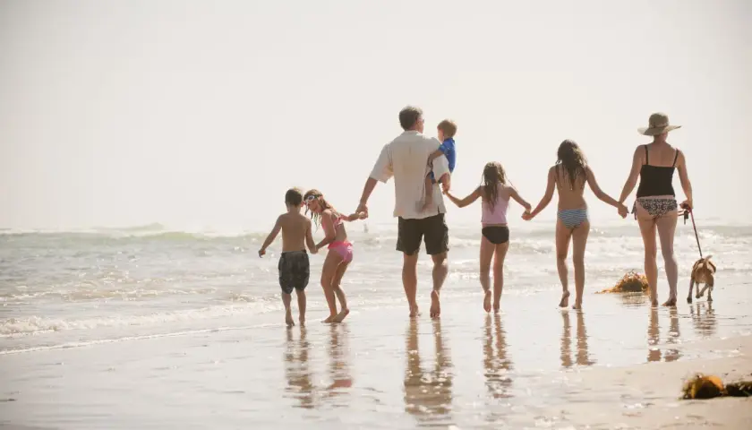Rodzina z psem na plaży, idealna na kartę dużej rodziny dla kogoś, kto ceni wspólne chwile.