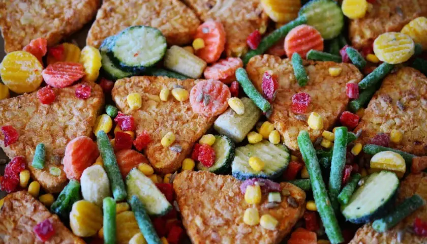 Un mix di cibi processati: patate fritte, carote, piselli, mais, zucchine e fagiolini. Un esempio di cosa sono i cibi processati.