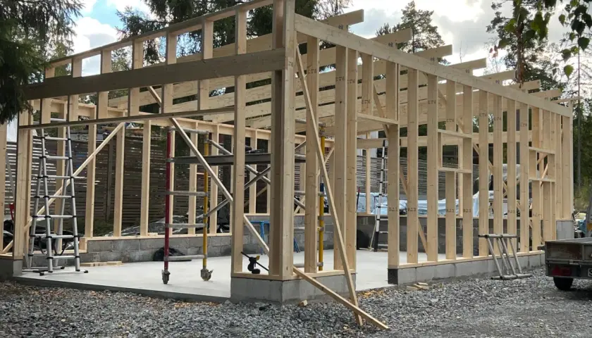 Trästomme till ett garage under uppbyggnad. Grunden är gjuten och stommen reses, vilket ger en bra uppfattning om bygga garage kostnad.