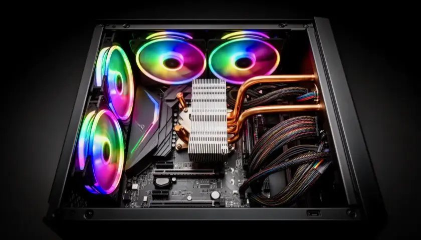 Intérieur d'un PC gaming avec ventilateurs RGB lumineux, un refroidisseur CPU imposant et des câbles colorés. Un vrai **3D mark** de performance.