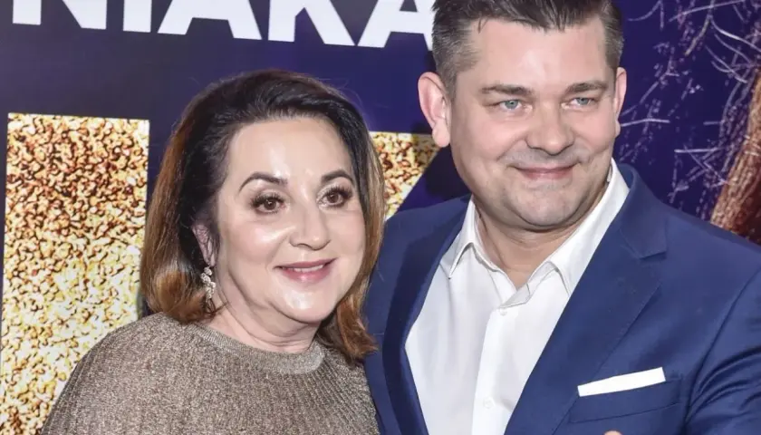 Danuta i Zenek Martyniuk pozują do zdjęcia. Kobieta ma złoty sweter, mężczyzna niebieski garnitur.