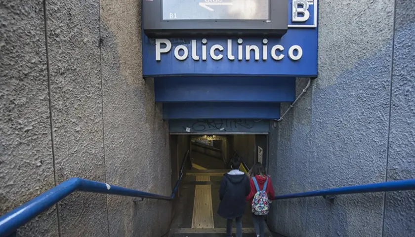 Due persone scendono le scale verso l'ingresso della stazione policlinico metro B.