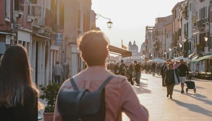 Promenade animée à Venise, près du Campo dei Mori, au coucher du soleil. Des passants flânent le long des bâtiments colorés.
