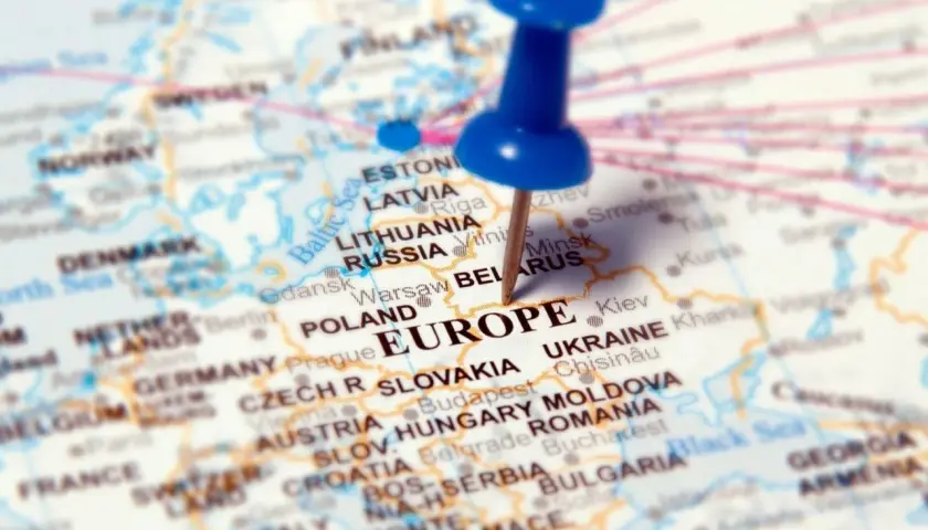 Mapa Europy z zaznaczonymi krajami, w tym Polską i Ukrainą. Niebieska pinezka wbita w Europę.