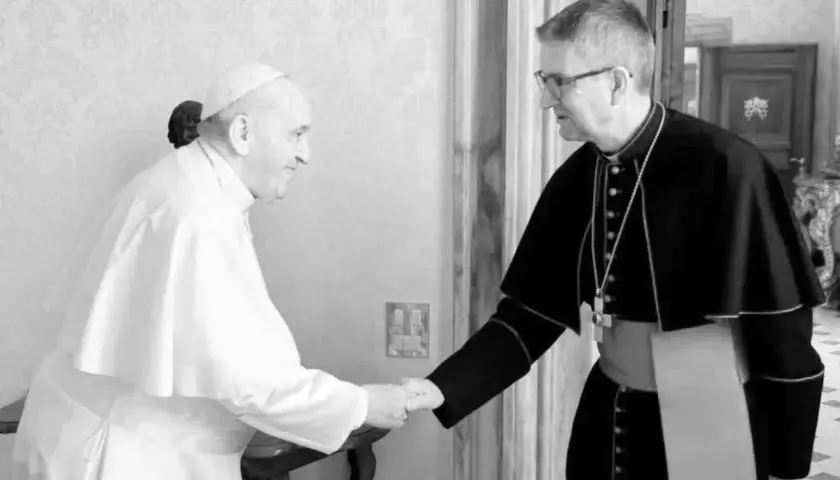 Papst Franziskus, seit wann ist Franziskus Papst, schüttelt einem Bischof die Hand.