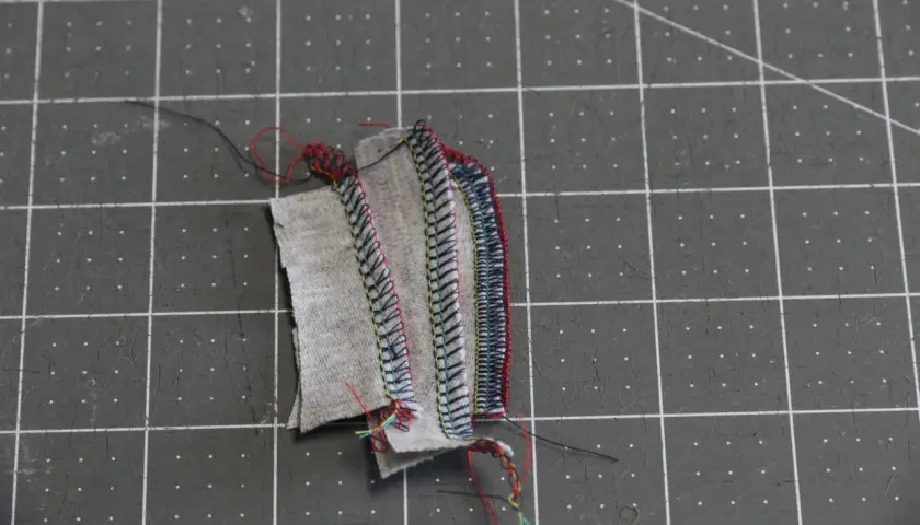 Serger troubleshooting: tangled threads and uneven stitches on fabric scraps.