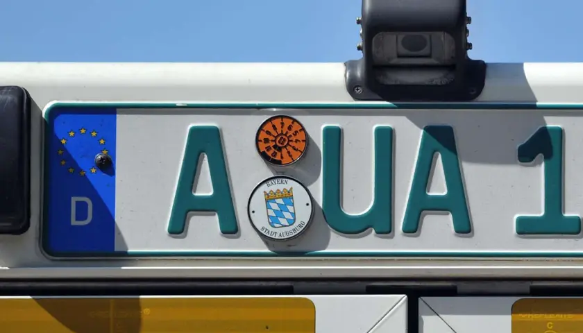 Kennzeichen "AQUA 1" auf einem Traktor. Das schwarze Kennzeichen hat ein EU-Feld und das Stadtwappen von Augsburg.
