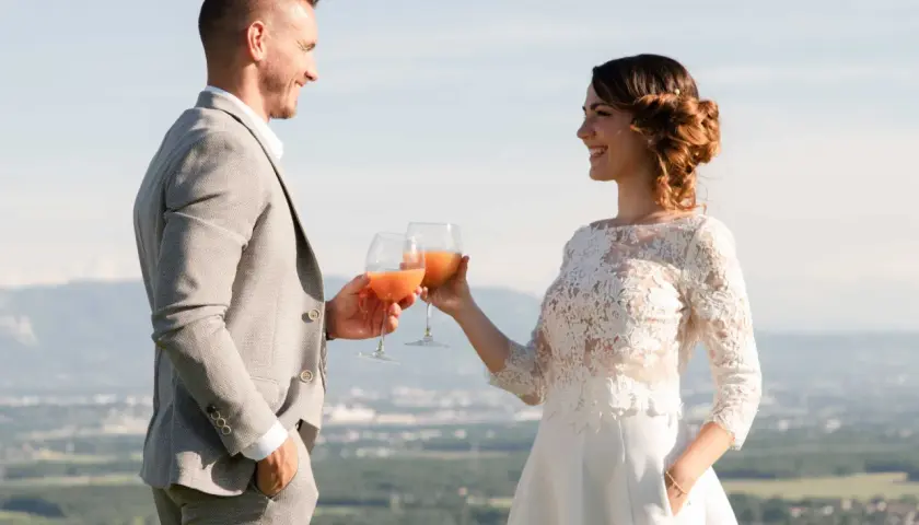 Jeune mariés trinquant avec des verres de boisson fruitée, une belle quantité pour célébrer leur amour.