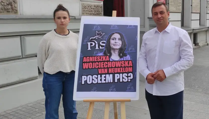 Agnieszka Wojciechowska van Heukelom, czy jest posłem PiS? Mężczyzna i kobieta stoją obok plakatu z jej zdjęciem.