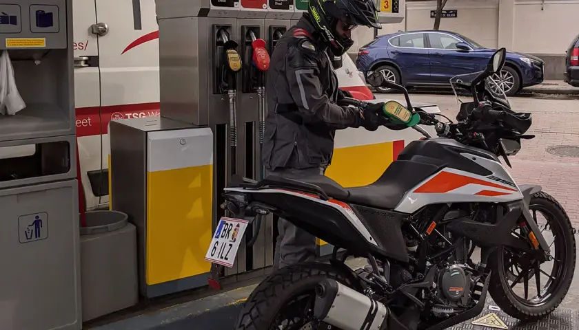 Motociclista repostando su moto 125. La pregunta clave es: ¿qué gasolina usan las motos 125? Generalmente, usan gasolina sin plomo de 95 octanos.