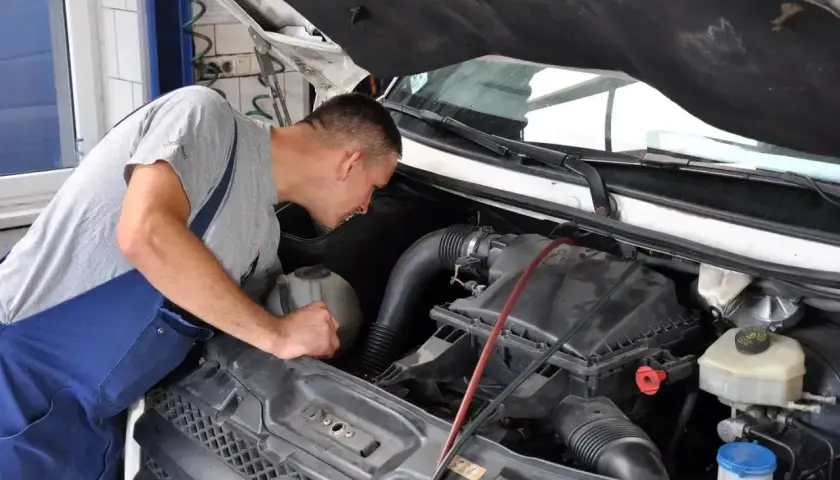 Mechanik bada silnik, szukając przyczyn wypadania zapłonu diesel.
