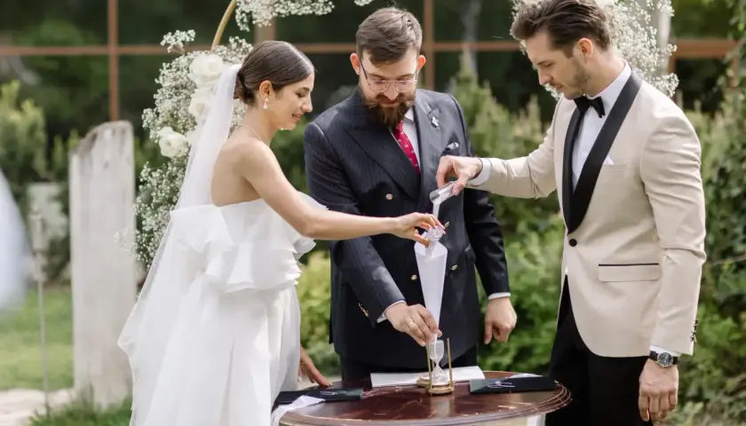 Para młoda i celebrans podczas ceremonii wsypywania piasku.