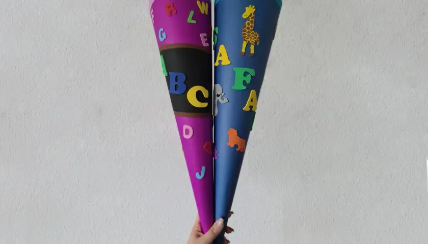 Zwei bunte Schultüten, liebevoll gestaltet mit Buchstaben und Tieren, sind bereit für den ersten Schultag. Ein tolles Ergebnis vom **Schultüte basteln**!
