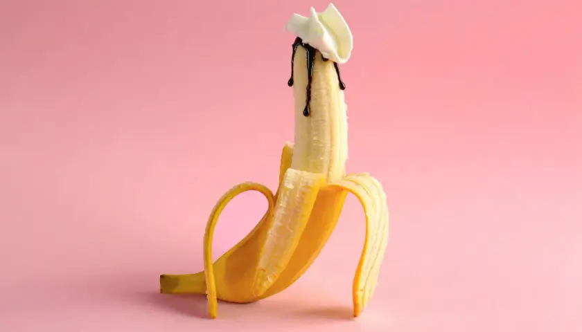 Banan z polewą czekoladową i bitą śmietaną, sugerujący polknięcie spermy.