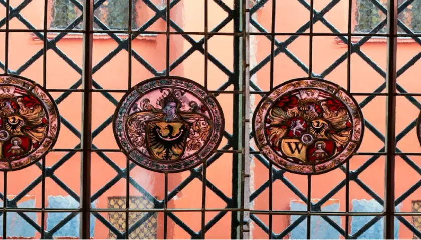 Witraże z herbami zdobią okna muzeum sztuki mieszczańskiej, ukazując bogactwo dawnych rodów.