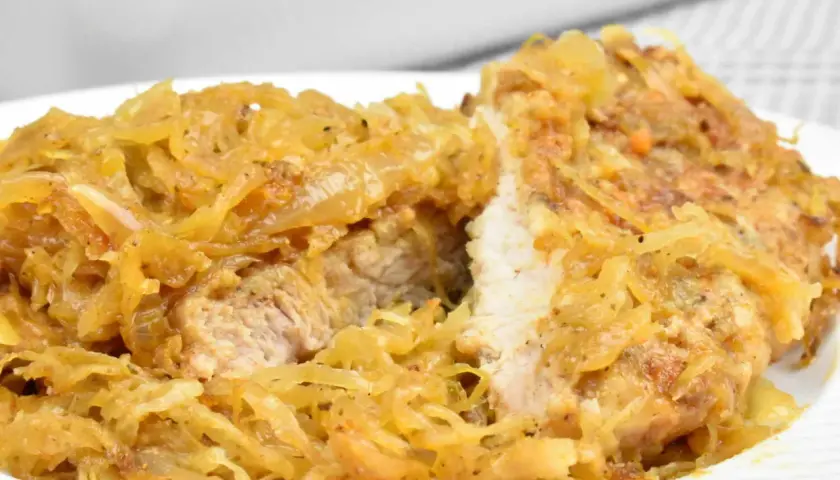 Schab w kapuście kiszonej, danie Ani, wygląda apetycznie. Mięso jest soczyste, a kapusta lekko zrumieniona.