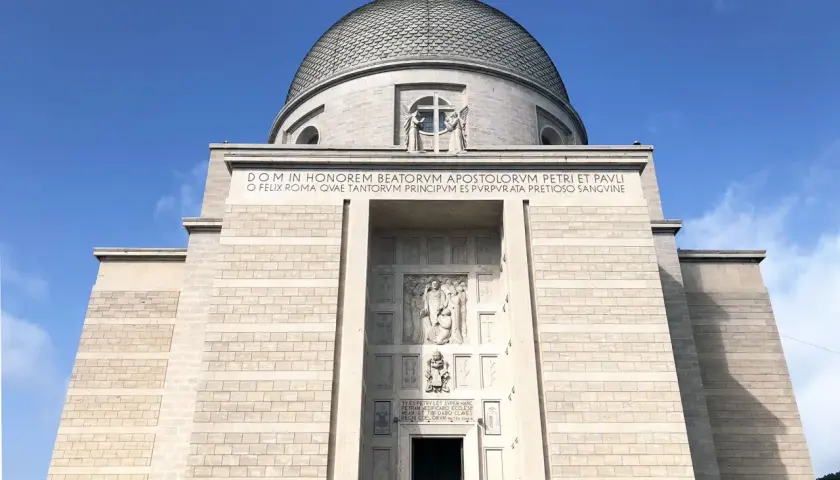 La maestosa chiesa San Pietro e Paolo domina il cielo azzurro, con la sua imponente cupola e iscrizioni latine che celebrano gli apostoli.